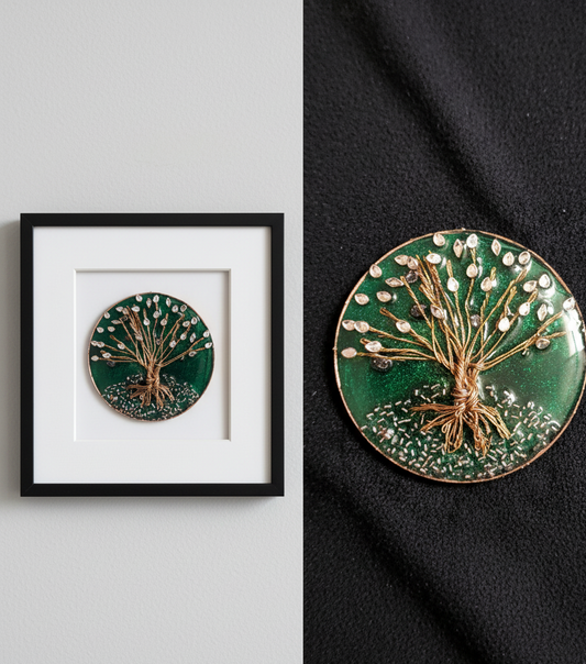 Decorative circular piece with tree design on a green background, framed on a gray wall.